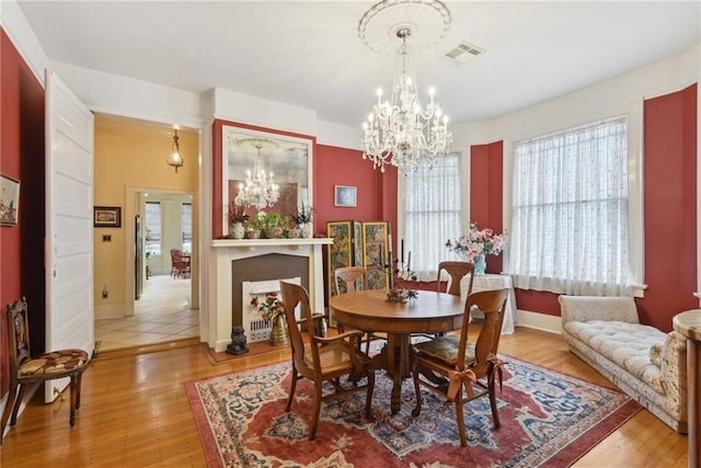 dining area with an inviting chandelier and hardwood / wood-style flooring