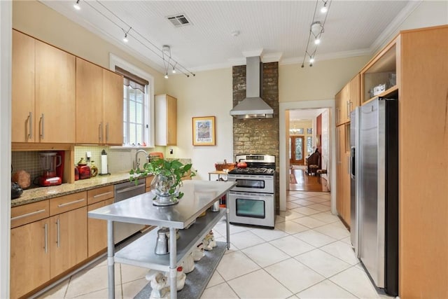 kitchen with rail lighting, wall chimney range hood, backsplash, appliances with stainless steel finishes, and ornamental molding