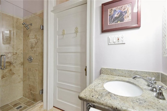 bathroom featuring a shower with door and vanity