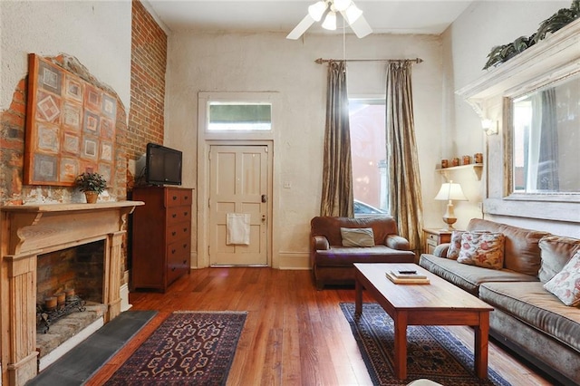 living room with ceiling fan, wood-type flooring, a fireplace, and a wealth of natural light