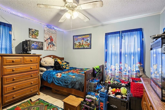 bedroom featuring ceiling fan, light tile patterned flooring, a textured ceiling, and ornamental molding