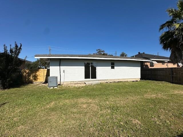 back of house with a yard and central AC unit