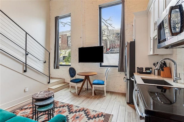 living area with sink and light hardwood / wood-style floors