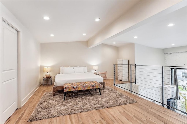 bedroom with vaulted ceiling with beams, light hardwood / wood-style floors, and access to exterior