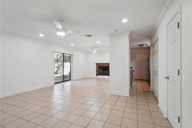 unfurnished living room featuring ceiling fan, ornamental molding, light tile patterned floors, and a tiled fireplace