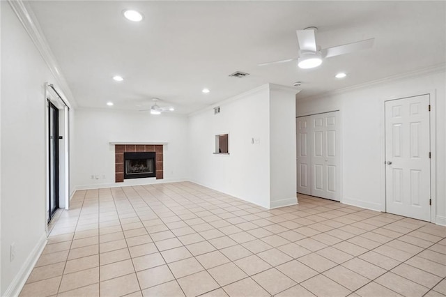 unfurnished living room featuring ceiling fan, a fireplace, light tile patterned floors, and crown molding