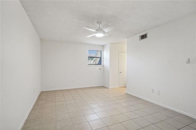 unfurnished room featuring ceiling fan, light tile patterned floors, and a textured ceiling