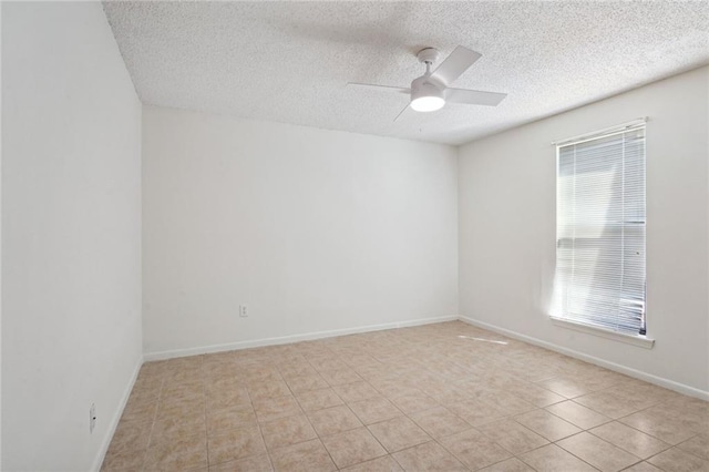 tiled empty room with ceiling fan and a textured ceiling