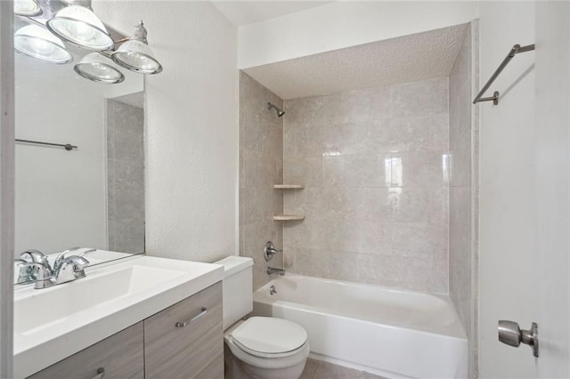 full bathroom with a textured ceiling, vanity, toilet, and tiled shower / bath