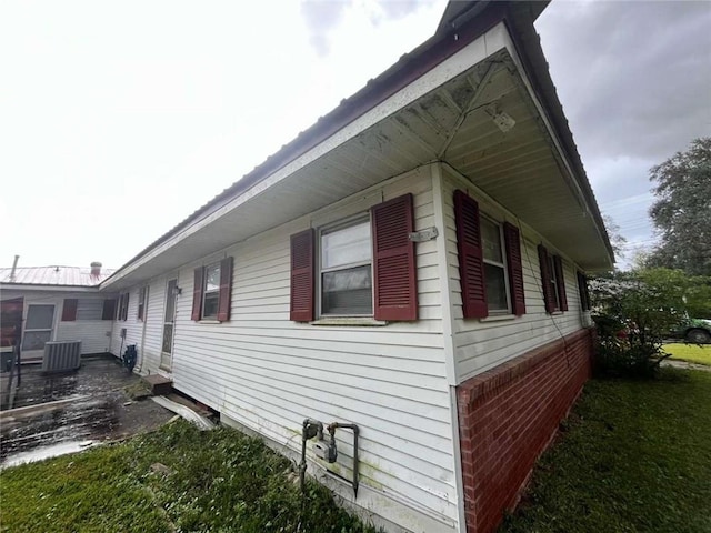 view of property exterior with a lawn and central AC