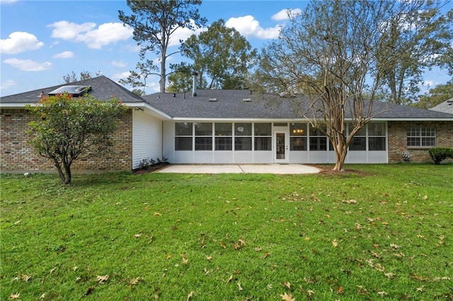 rear view of house with a lawn, a sunroom, and a patio area