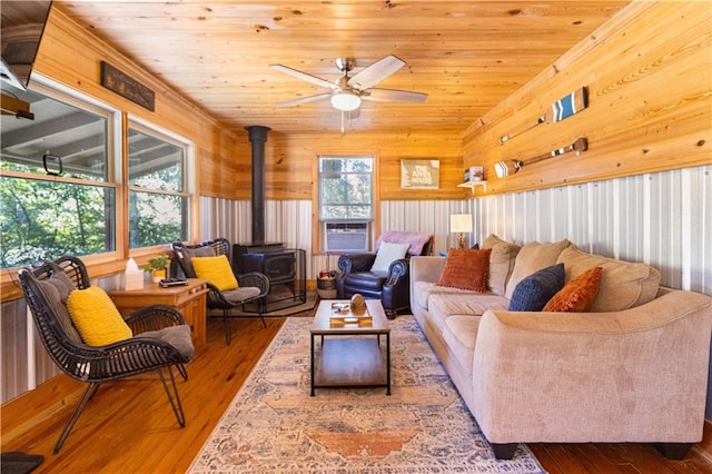 living room featuring hardwood / wood-style floors, a wood stove, a wealth of natural light, and vaulted ceiling