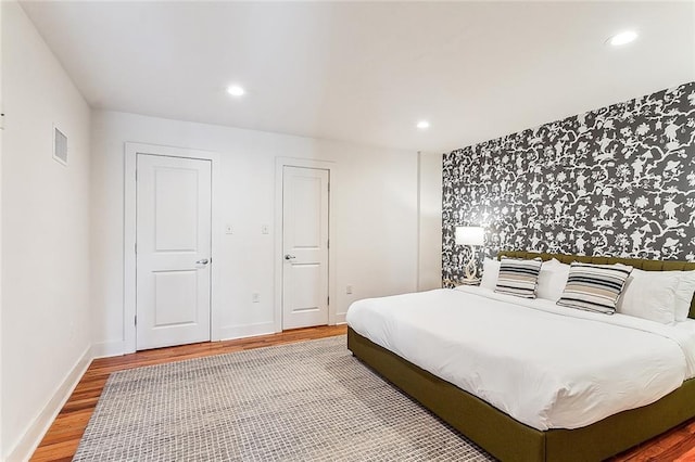 bedroom featuring recessed lighting, visible vents, and wood finished floors