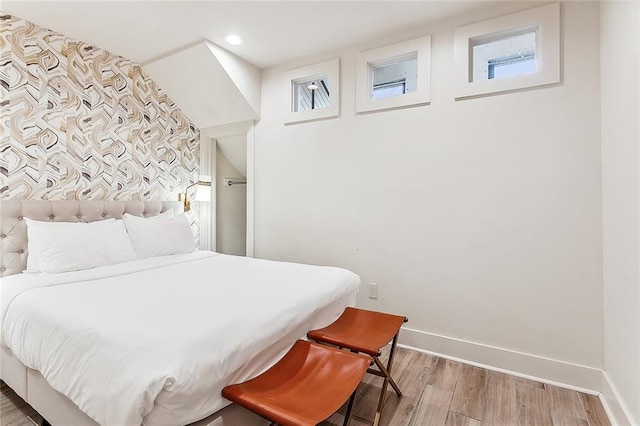 bedroom featuring multiple windows, wood finished floors, recessed lighting, and baseboards