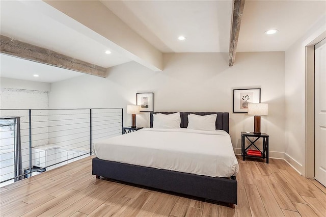 bedroom with beamed ceiling, recessed lighting, baseboards, and light wood-style floors