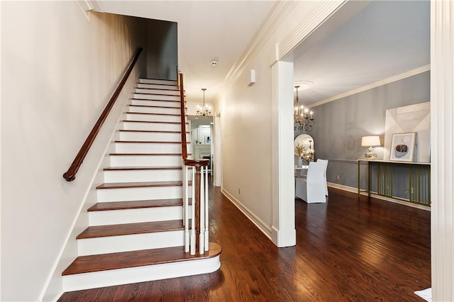 stairway with a chandelier, wood-type flooring, and ornamental molding