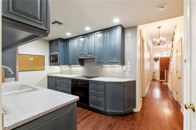 kitchen with sink, dark hardwood / wood-style flooring, a notable chandelier, backsplash, and black appliances