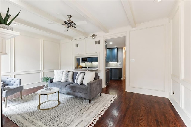 living room with beam ceiling, dark hardwood / wood-style floors, ceiling fan, and sink