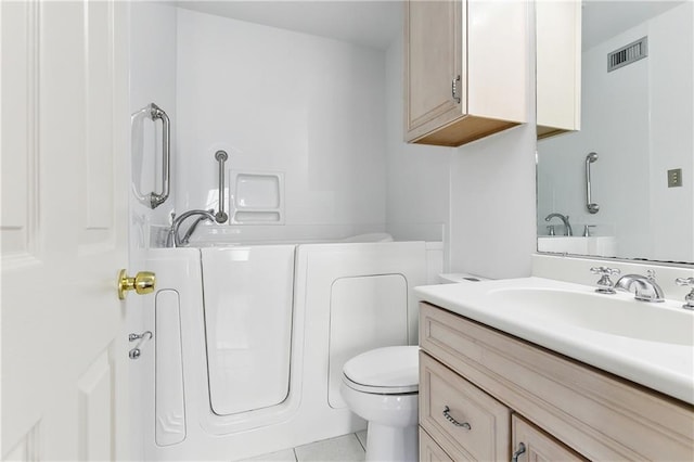 bathroom with tile patterned flooring, vanity, toilet, and a bathtub