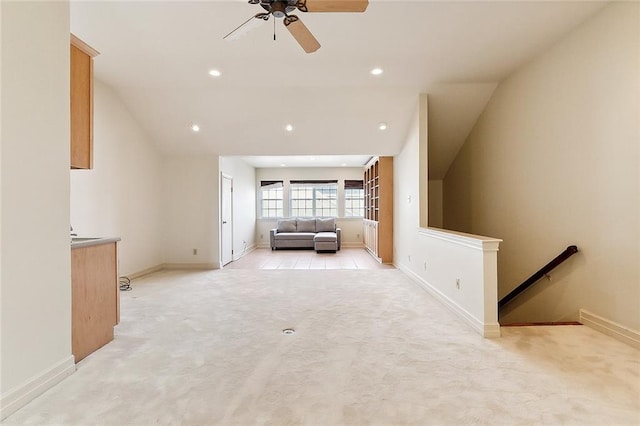 interior space with ceiling fan, light colored carpet, and lofted ceiling