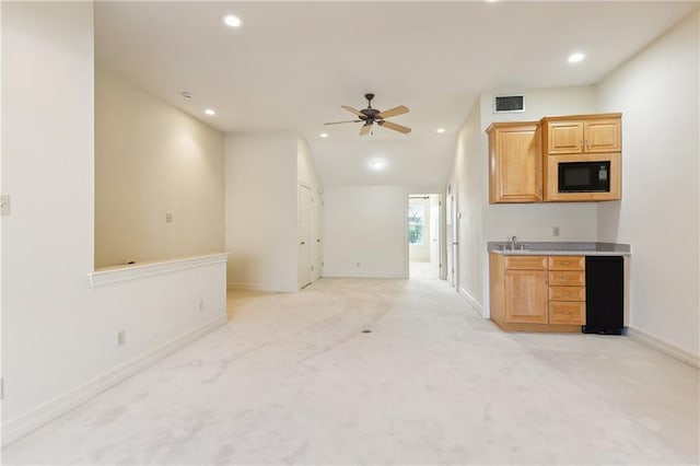 kitchen featuring ceiling fan, light colored carpet, lofted ceiling, and black microwave