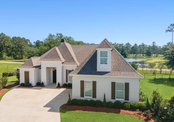 view of front of home with a front lawn and a water view