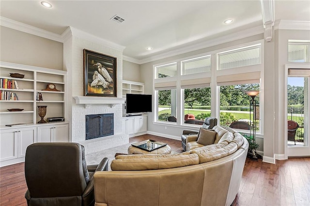 living room featuring dark wood-type flooring, a fireplace, and ornamental molding