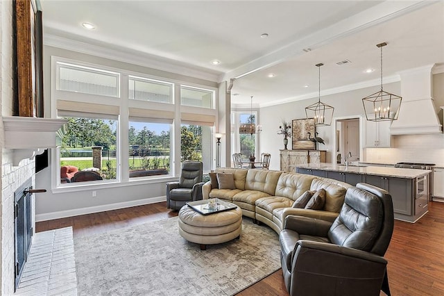 living room with ornamental molding, sink, a fireplace, and dark hardwood / wood-style flooring