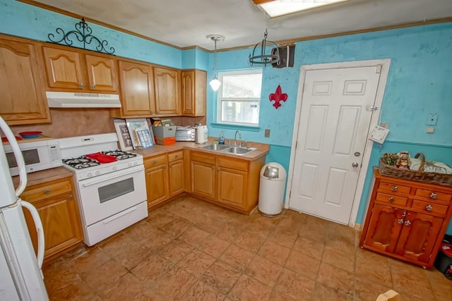 kitchen featuring decorative light fixtures, white appliances, and sink