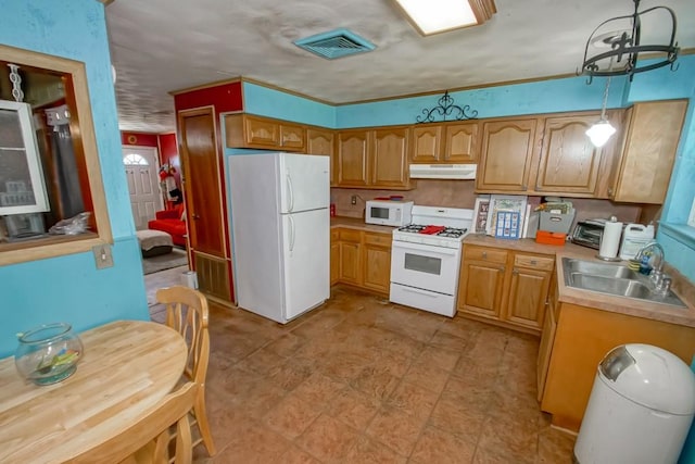 kitchen featuring pendant lighting, white appliances, and sink