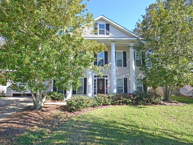 neoclassical home with a front yard and concrete driveway