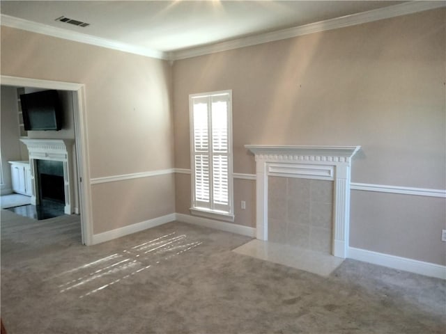 unfurnished living room featuring visible vents, ornamental molding, baseboards, a fireplace with flush hearth, and carpet