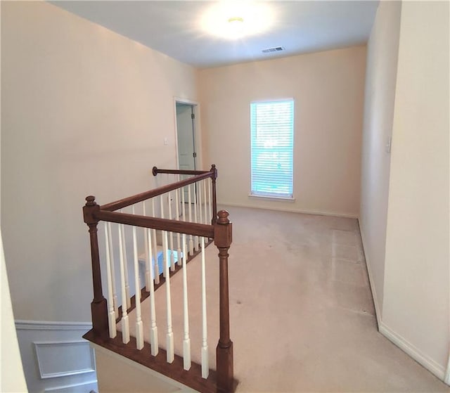 stairs with visible vents, carpet floors, and a wainscoted wall