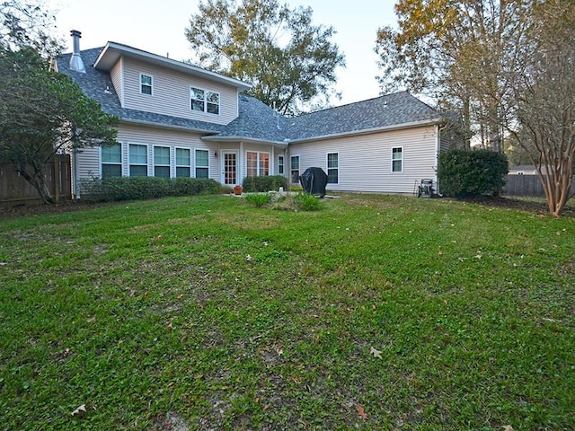 back of house featuring a lawn