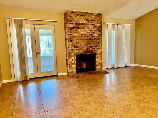 unfurnished living room featuring a fireplace, a textured ceiling, and tile patterned floors