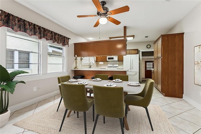 dining area with ceiling fan, sink, and light tile patterned floors