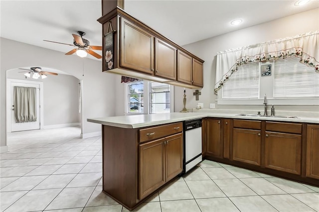 kitchen featuring dishwasher, sink, ceiling fan, light tile patterned floors, and kitchen peninsula