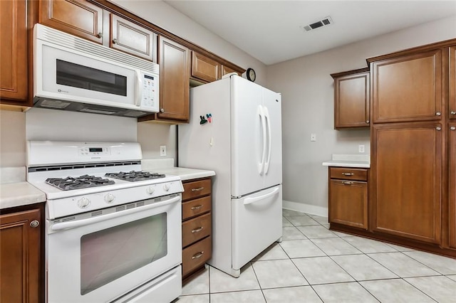 kitchen featuring light tile patterned floors and white appliances