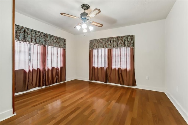 empty room with hardwood / wood-style flooring, plenty of natural light, and ceiling fan