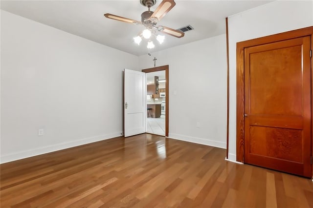 unfurnished bedroom with ceiling fan and hardwood / wood-style floors