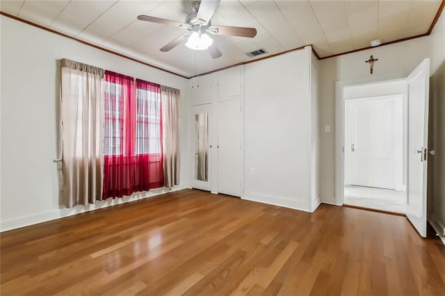 spare room featuring ceiling fan, wood-type flooring, and crown molding