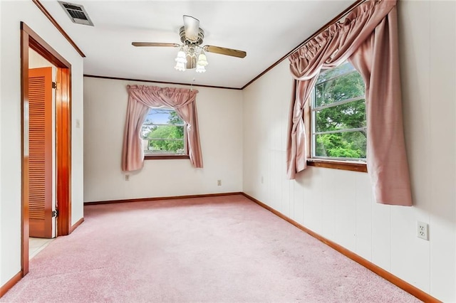 unfurnished room featuring light colored carpet, ceiling fan, and crown molding