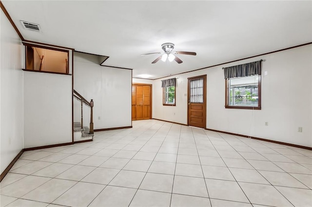 spare room featuring ceiling fan, a healthy amount of sunlight, and light tile patterned floors