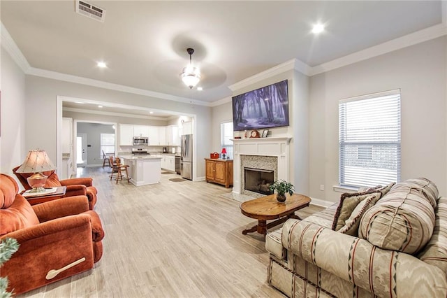 living room featuring ceiling fan, light hardwood / wood-style floors, and ornamental molding