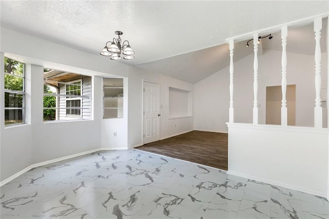 unfurnished dining area with a textured ceiling, hardwood / wood-style flooring, lofted ceiling, and a notable chandelier