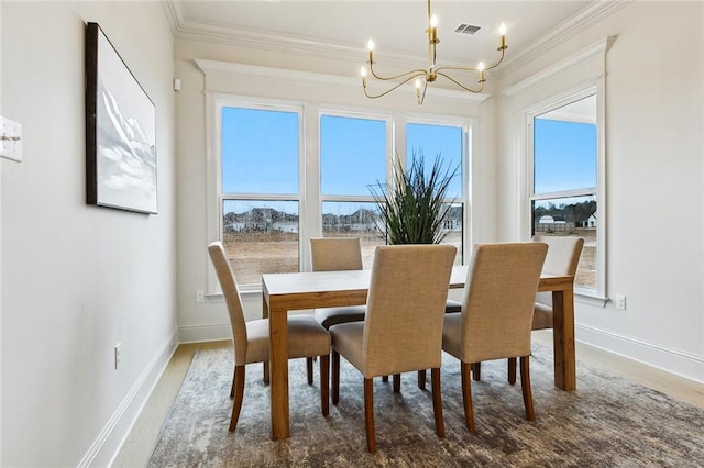 dining area with crown molding, wood-type flooring, and an inviting chandelier