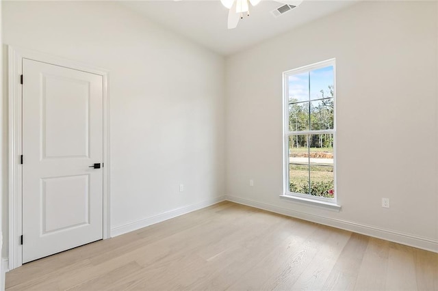 spare room featuring ceiling fan, a wealth of natural light, and light wood-type flooring