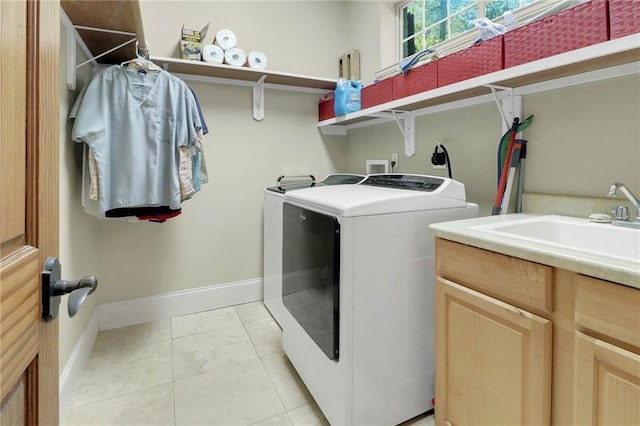 laundry area featuring light tile patterned flooring, cabinets, separate washer and dryer, and sink