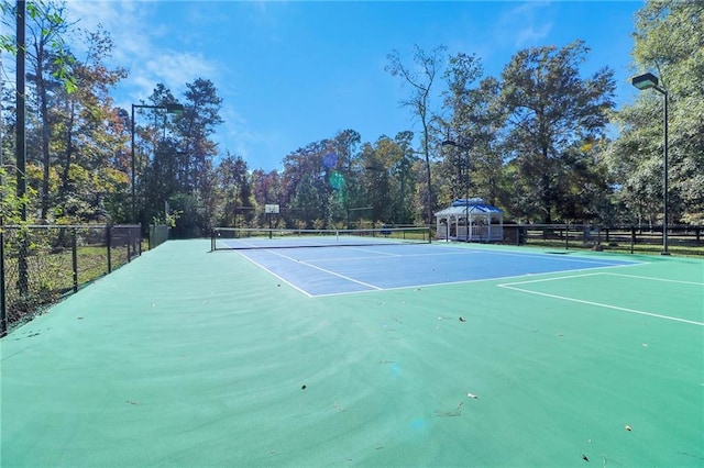 view of tennis court featuring basketball hoop