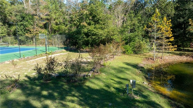 surrounding community featuring a water view, a lawn, and tennis court